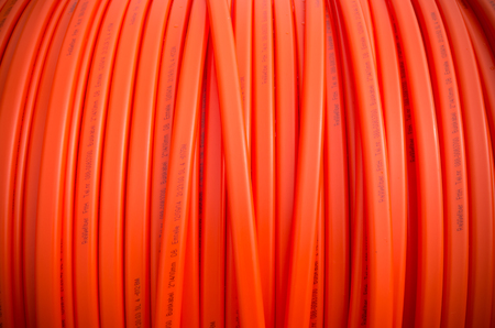 HENGELO, NETHERLANDS - MARCH 28, 2015: Closeup of orange fiber cable owned by Reggefiber, a Dutch company that specializes in the installation of fiber optic connectionsのeditorial素材