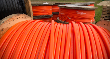 HENGELO, NETHERLANDS - MARCH 28, 2015: Drums with orange fiber cable owned by Reggefiber, a Dutch company that specializes in the installation of fiber optic connectionsのeditorial素材