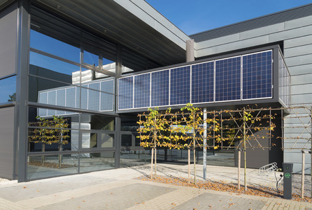 modern office building exterior with solar panels above the entrance