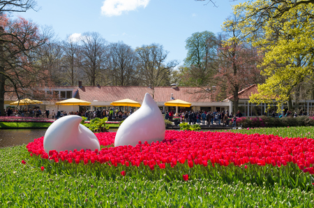 LISSE, NETHERLANDS - APRIL 17, 2016: Art objects in a field of blooming red tulips in the famous Keukenhof Gardens in the netherlandsのeditorial素材