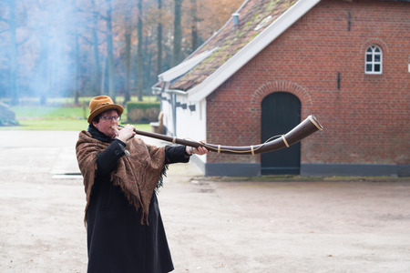 OLDENZAAL, NETHERLANDS - NOVEMBER 27, 2016: Unknown woman blowing a so called "midwinterhorn", a traditional handmade wooden instument. It is used in the advent period in some eastern parts of the netherlandsのeditorial素材