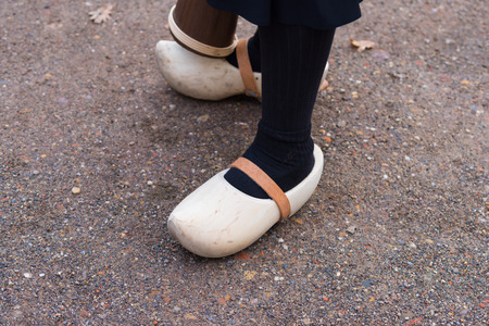 woman legs with a pair of pretty new wooden clogs with leather strapsの写真素材