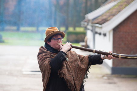 OLDENZAAL, NETHERLANDS - NOVEMBER 27, 2016: Unknown woman blowing a so called "midwinterhorn", a traditional handmade wooden instument. It is used in the advent period in some eastern parts of the netherlandsのeditorial素材