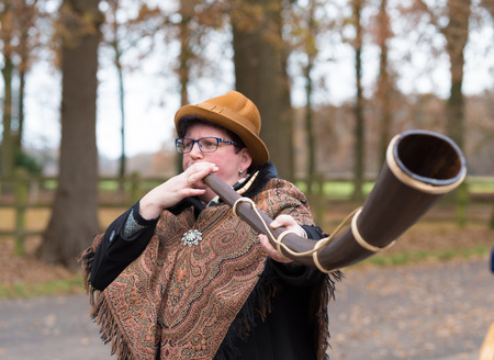 OLDENZAAL, NETHERLANDS - NOVEMBER 27, 2016: Unknown woman blowing a so called "midwinterhorn", a traditional handmade wooden instument. It is used in the advent period in some eastern parts of the netherlandsのeditorial素材