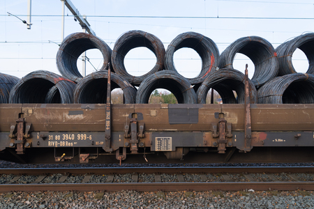row of train cargo wagons with rolls of steel wireの写真素材