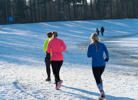 OLDENZAAL, NETHERLANDS - JANUARY 22, 2017: Unknown female athletics doing a cross run in a snow white landscapeのeditorial素材