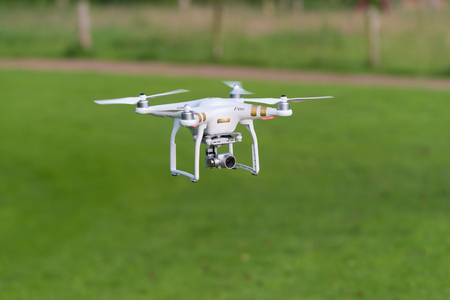 OLDENZAAL, NETHERLANDS - JUNE 19, 2016: DJI Phantom drone with camera attached flying low above the...