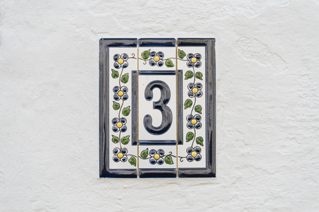 house number three decorated with tiles on a white wallの写真素材