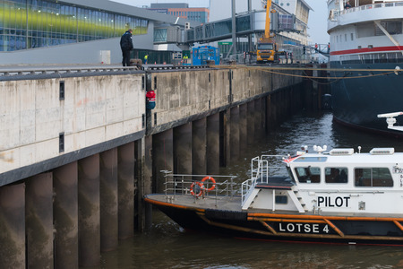 HAMBURG, GERMANY - DECEMBER 20, 2016: Pilot boat picking up a pilot from a high Elbe river quayのeditorial素材