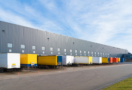 Large commercial warehouse with trailers in frontの写真素材