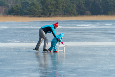 LATTROP, NETHERLANDS - MARCH 3, 2018: Unknown person helping her little child how to skateのeditorial素材