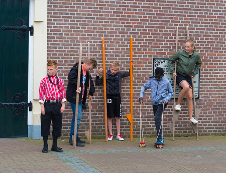 URK, NETHERLANDS - MAY 19, 2018: Unknown children walking stalks on the annual Urkerdays. Urk is on of the best-known fishing villages in the country with the largest fishing fleet.のeditorial素材