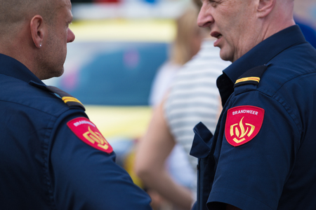 ROTTERDAM, NETHERLANDS - SEPTEMBER 3, 2017: Two firefighters talking during the Rotterdam port days