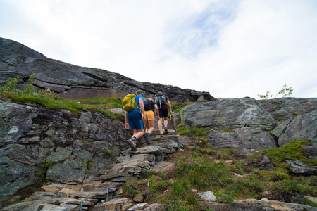 TROLLSTIGEN, NORWAY - JULY 30, 2018: Unknown tourists hiking up upon the hill for a better point of view over the famous troll pathのeditorial素材
