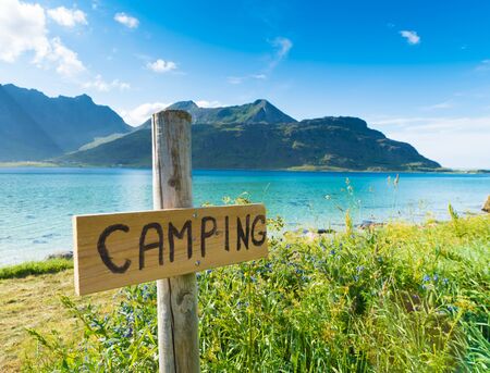 wooden camping sign along a amazing azur blue fjord on the lofoten islands in Norwayの写真素材