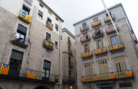 facades and houses in cataluna, spain, decorated with independence flags and yellow ribbonsの写真素材