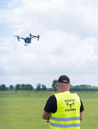 NIJVERDAL, NETHERLANDS - JUNE 23, 2018: Professional drone pilot controling a drone with camera