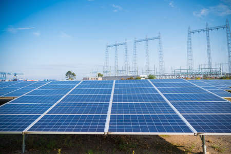 solar park in the Netherlands with some electricity pylons in the backgroundの写真素材