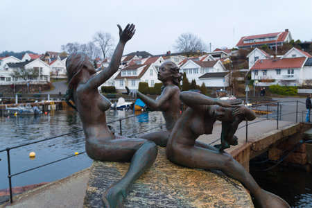 DROBAK, NORWAY - DECEMBER 22, 2019: View on the Drobak harbor with the three mermaids sculpture. . They were given to the town by Ingeborg Drangsholt thanking the local people for their great helpfulness. She moved to London in 1963.のeditorial素材