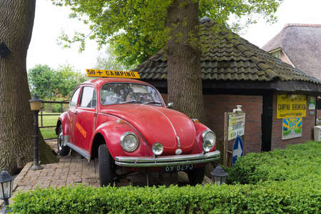 HAARLE, NETHERLANDS - MAY 10, 2020: Red oldtimer VW beetle car as a signboard for a 50+ campingのeditorial素材