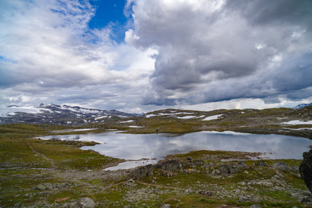beautiful norwegian landscape with hills and a lake in frontの写真素材