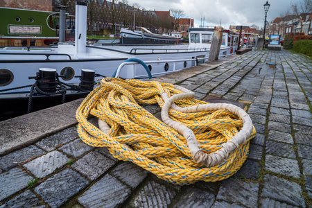 piece of rope lying on the quay next to a boatの写真素材