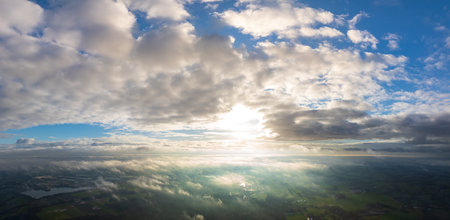 aerial photo of the sun shining above a foggy landscapeの写真素材