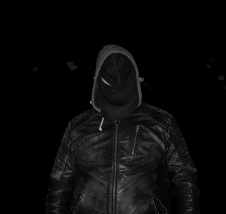 creepy person fully dressed in black wearing a black face mask