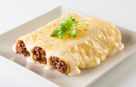 Delicious meat filled pasta on a plate. Italian cannelloni, Spanish canelones.の写真素材