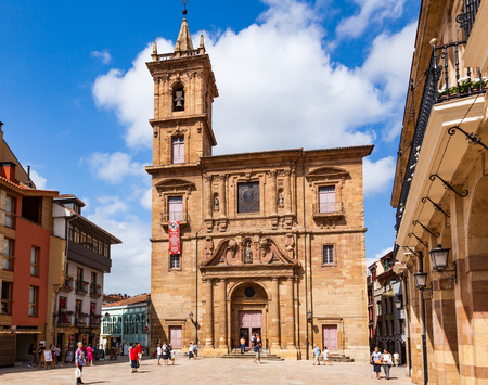 OVIEDO, SPAIN - AUGUST 14, 2013: Tourists and local residents stoll on the Plaza Nueva square with the San Isidoro church.のeditorial素材