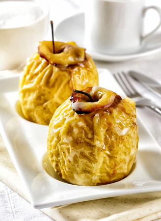 Oven baked apples served on a white plate.の写真素材