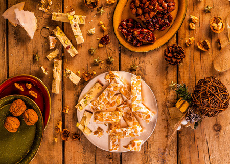 Nougat and Christmas decorations on a wooden table. Top view.の写真素材