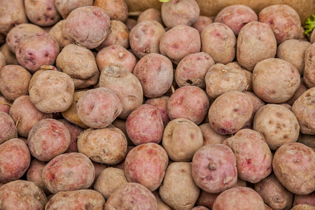 Red potatoes for sale at a market stall.の写真素材