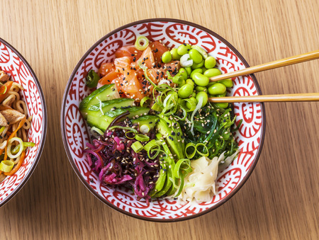 Poke dish with salmon. Top view on wooden table.の写真素材