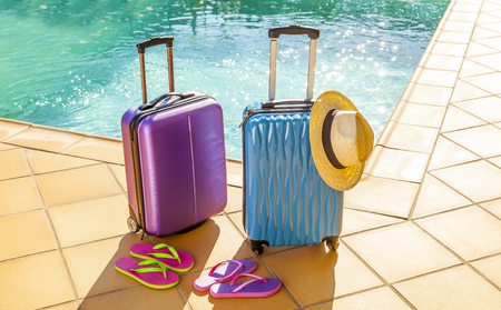 Summer vacation travel concept: suitcases, sandals and hat at the pool.の写真素材