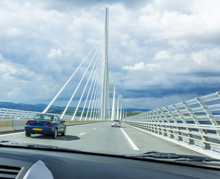 MILLAU, FRANCE - JULY 27, 2011: Millau Viaduct in Southern France. People in cars drive over the bridge which is part of the A75-A71 autoroute axis from Paris to Beziers and Montpellier.のeditorial素材