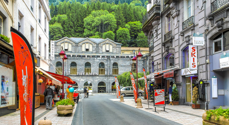 LE MONT-DORE, FRANCE - JULY 28, 2011: Summer 2011. Tourists stroll along the Rue Ramond, the main street of the thermal spring town of Le Mont-Dore, located in central France.のeditorial素材