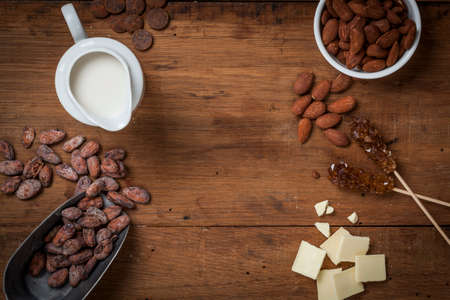 Top view of an old wooden table with milk chocolate ingredients and copy space.の写真素材