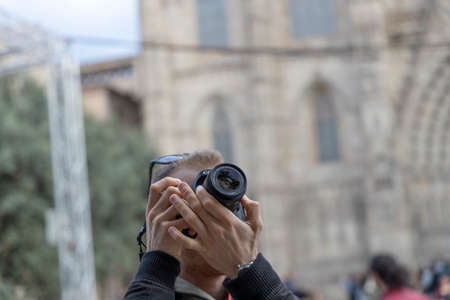 BARCELONA, SPAIN - NOVEMBER 23, 2019: A tourist takes pictures of the cathedral of Barcelona.のeditorial素材