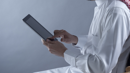 Saudi Arabian Man Hands Holding and Using Tabletの写真素材