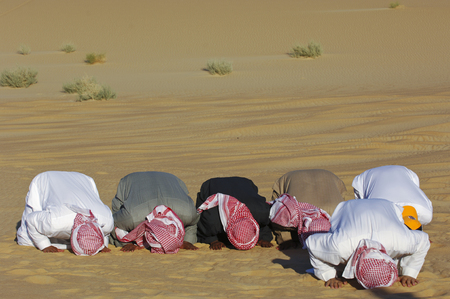 Arab men praying Asr in the desertの写真素材