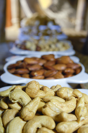 Almonds, Pistachios, Cashew Mix of Nuts in white Platesの写真素材