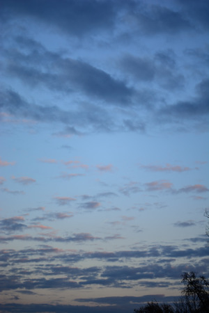 white, pink and gray clouds in autumn evening sky just before sunsetの写真素材