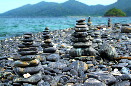 Many beauty pebble on koh Hin Ngam Island near Kor Lipe Island, Andaman sea, Satun, Thailand with mountain and nice sea backgroundの写真素材