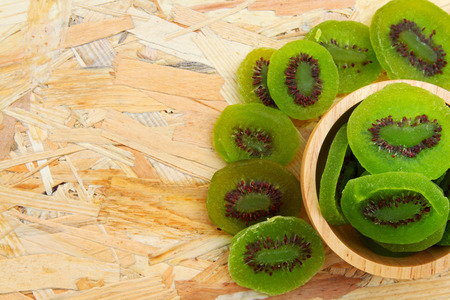 Dried Kiwi in wooden bowl and on wooden table background with left copy space.の写真素材