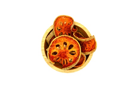 Many sliced of dry bael fruit on the wooden bowl and isolated on white backgroundの写真素材