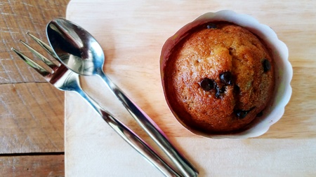 Top view of homemade banana cupcake with spoon and fork on the wooden plate - Dessert  and bread...