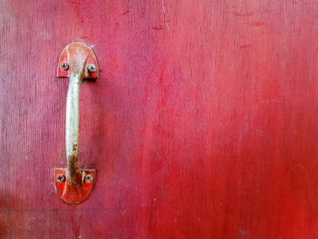 Close up metal handle of door or window on the red wooden background painted with copy space - Art and Abstract wallpaper conceptの写真素材