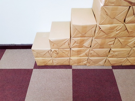 Many stack of brown package boxes on the purple rug and white wall with copy space - Packaging store for business book storeの写真素材