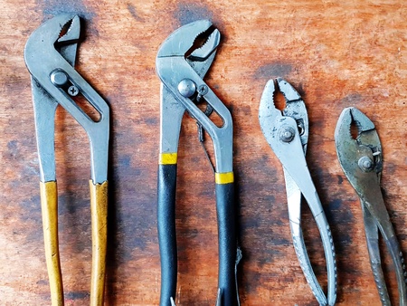 Four different size of pliers on the wooden background at garage - Fixed and Industrial Maintenance conceptの写真素材